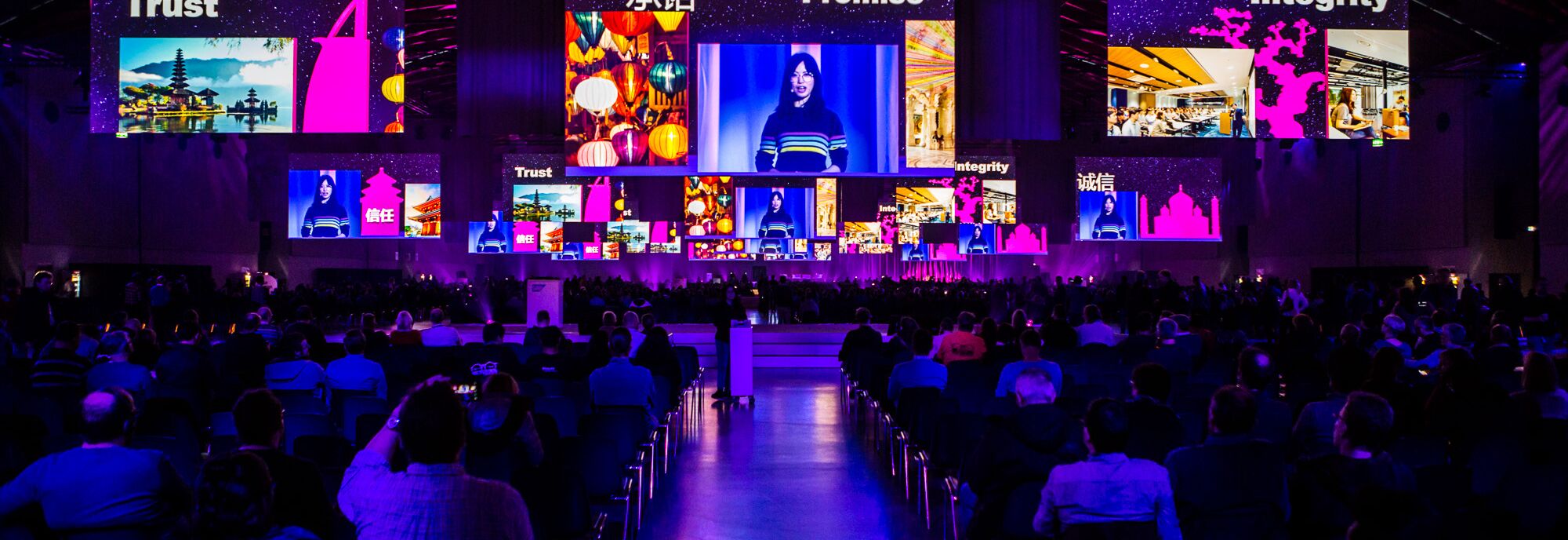 Bühnenbild mit LED-Wänden, Panels und Lichteffekten bei einem Event in dunkler Atmosphäre.