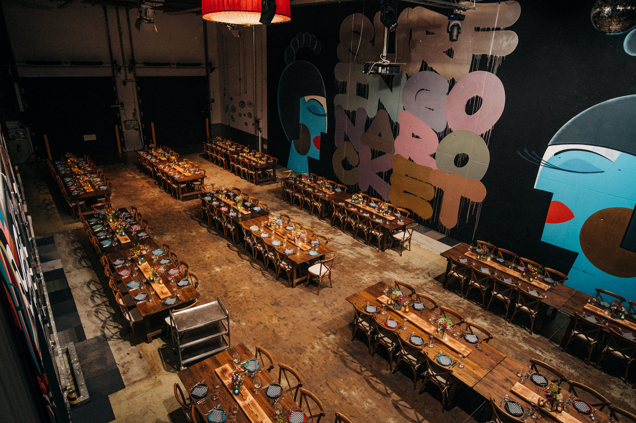 Eine große Halle mit großen Wandgemälden und langen, gedeckten Tischen